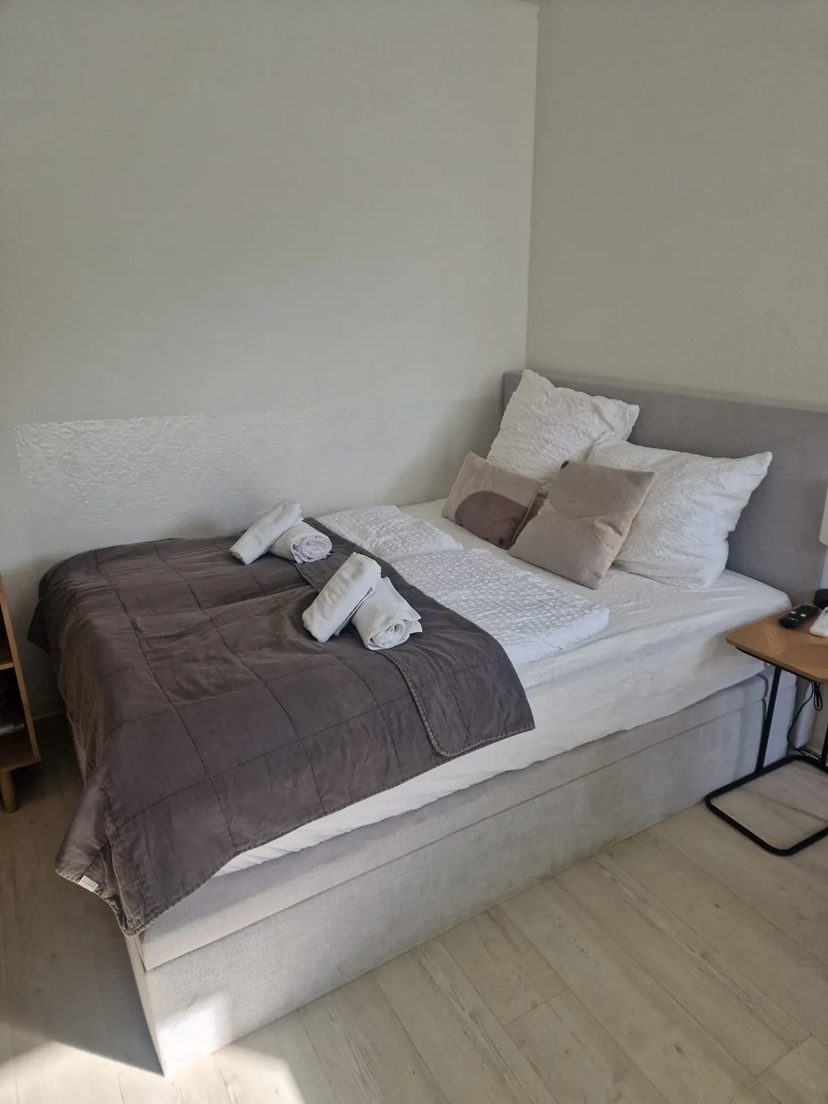 Vorbereitetes Bett mit gefalteten Handtüchern